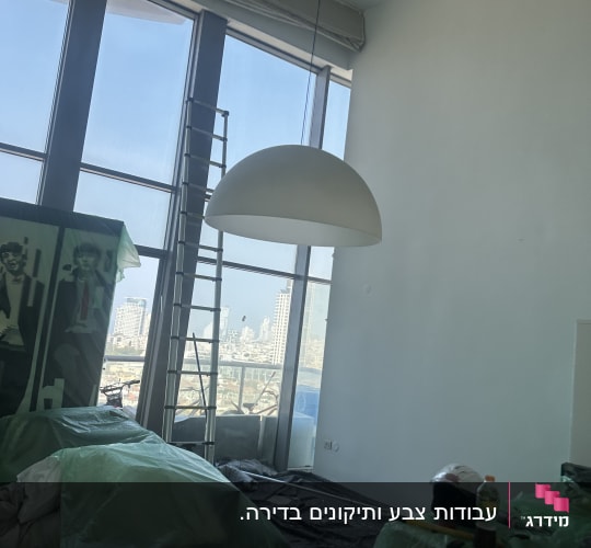 חדר עם קירות צבועים, סולם, וציוד צביעה